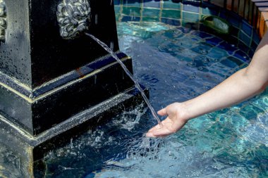 Bir çocuğun eline bir çeşme başından akan su.