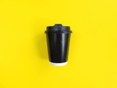 Sarı arka planda siyah kağıt kahve fincanı. Düz yatış stili. Minimum konsept. Stok fotoğrafçılığı.