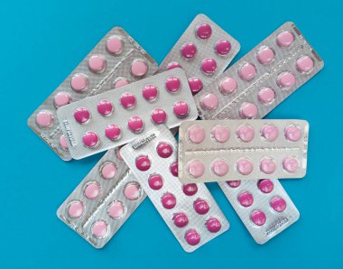 Mavi arka planda su toplamış pembe haplar. Tıbbi konsept. Stok fotoğrafçılığı.