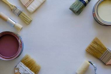 Beyaz arka planda kullanılmış fırçalar ve boya kutuları