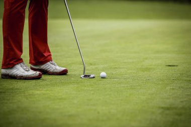 Yeşil koyarak golfçü bacaklarına delik yakınındaki. 