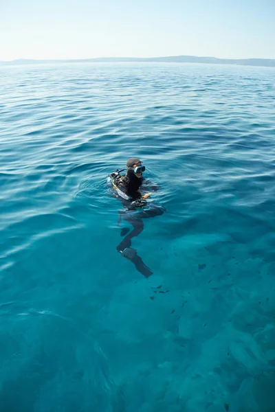 Scuba diver Hırvatistan Adriyatik Denizi yüzeyi. Düşük ihtimal. Su ufukta. 