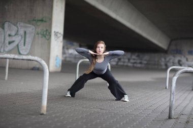 Kaldırımda gerçekleştirme kadın sokak dansçısı. Tam boy. 