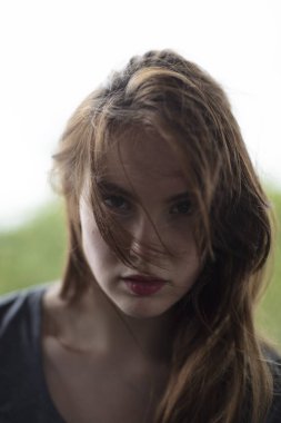Kadın modeli seductively saç kamerayla bakan yüzünde düşmüş. Yakın çekim. 