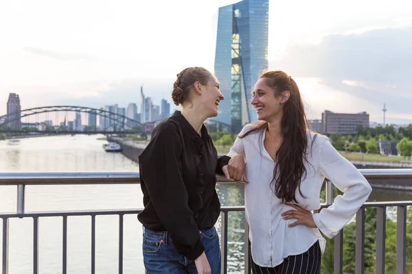 Girlfriends Standing City Bridge River Looking Each Other Laughing Medium — Stock Photo, Image
