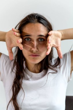 Kameraya bakarak yüzünü kaldırdı elleriyle Genç Hintli kadın. Yakın çekim. 