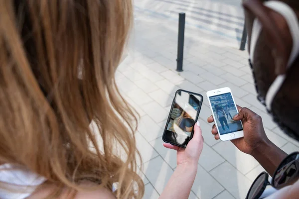 Mixed Race Couple Sharing Pictures Phone Screens Outdoors Shoulder View — Stock Photo, Image