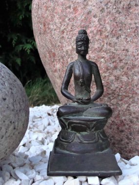 Japon tarzı bir bahçede bronz Buda heykelciği