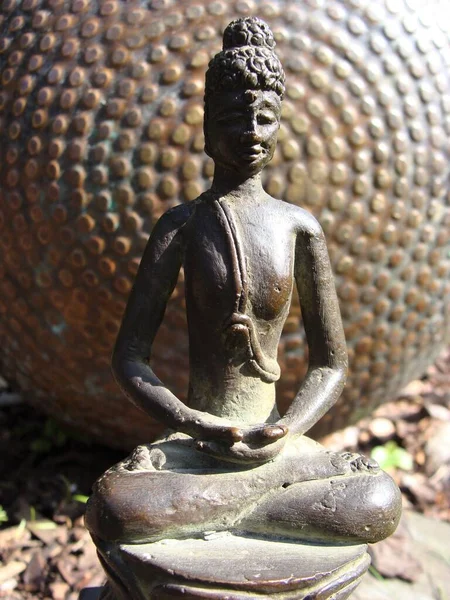 Japon tarzı bir bahçede bronz Buda heykelciği