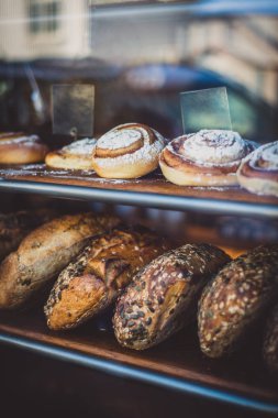 Taze pişmiş ekmek ve fırın penceresinde tarçın rulo
