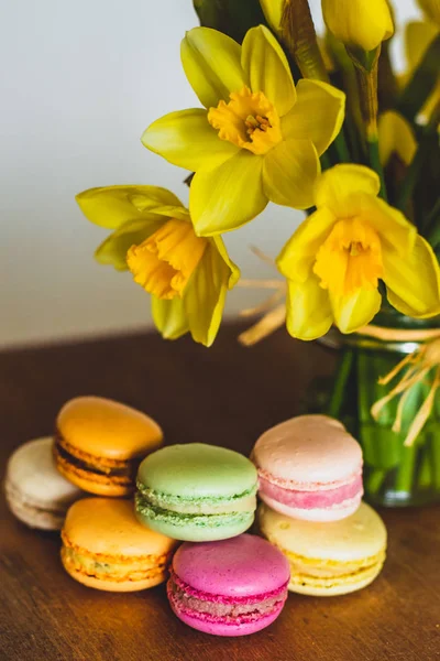 Sarı daffodils ve pembe yeşil turuncu ve Macenta macarons 