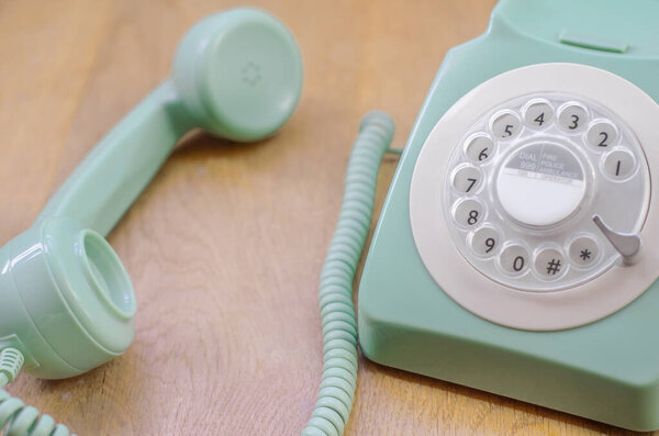 Close Up of a Rotary Phone With Handset Resting on a Table