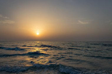 Sahilde muhteşem bir gün batımı. Akşam vakti. Suyu kapat..