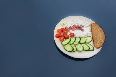 Salatalık, domates ve ekmekle servis edilen dilimlenmiş tuzlu domuz yağı. Geleneksel Rus yemeği. Ev yapımı yemek. Sağlıklı yiyecekler. Organik bileşenler alanı kopyala 
