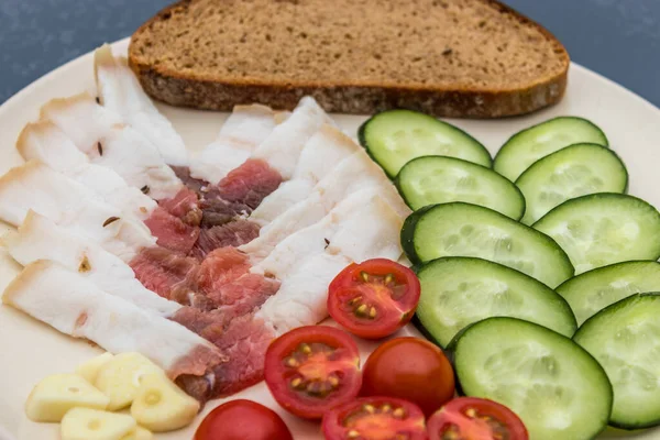 Sliced salted lard served with cucumber, tomato and bread. Traditional Russian snack. Homemade food. Healthy food. Organic ingredients — Stock Image Sliced Salted Lard Served Cucumber Tomato Bread Traditional Russian Snack Royalty Free Stock Photos