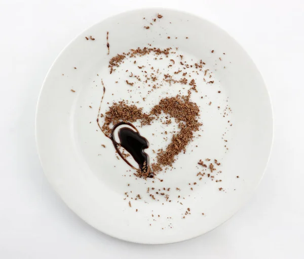 plate with grated and liquid chocolated in heart shape