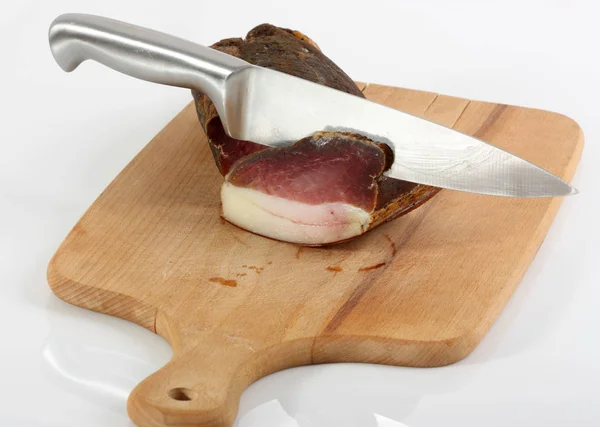 木製の板にナイフを持つ硬化肉の一部 — ストック写真