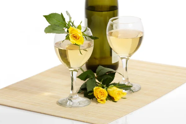 wine bottle with filled glasses and yellow roses