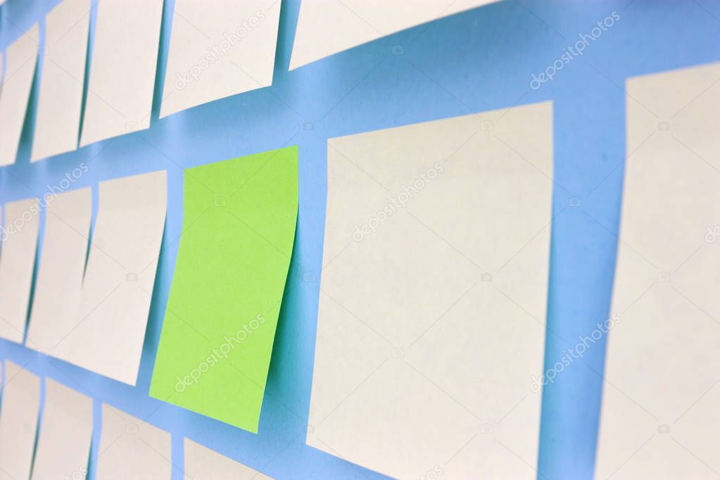 white and green paper stickers on blue wall