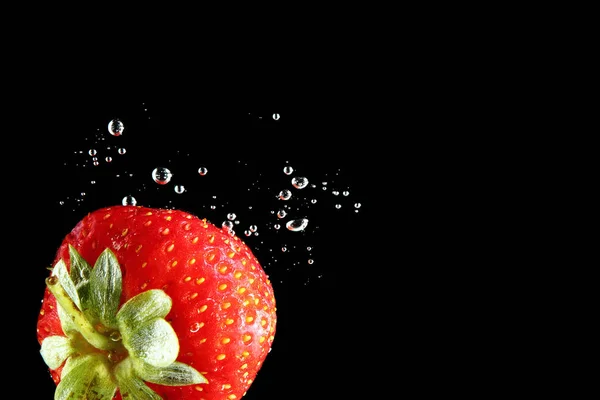 Erdbeere Fällt Vor Schwarzem Hintergrund Ins Wasser — Stockfoto