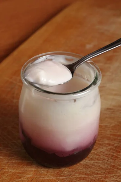 用水果酸奶在木制切菜板上打开的小玻璃瓶上 — 图库照片