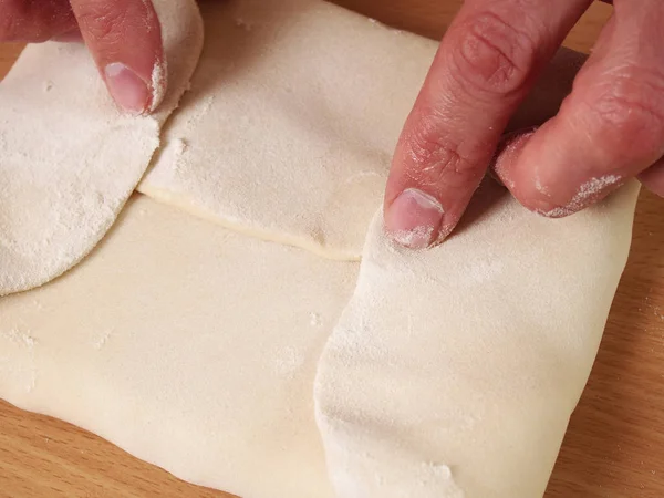 Wrap butter in dough. Bring each corner of the dough to the centre of the butter to enclose it completely. Making Puff Pastry Series.