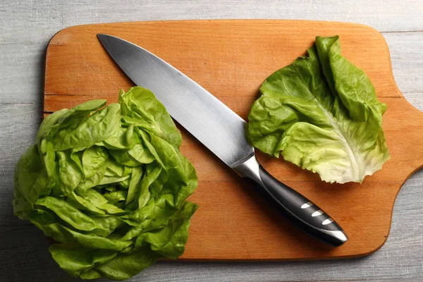 Butter lettuce with knife on kitchen board