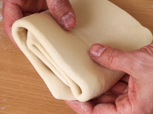 Fold up dough. Fold the lower third of the pastry over the centre third, and the top third of the pastry down over that. Making Puff Pastry Series.