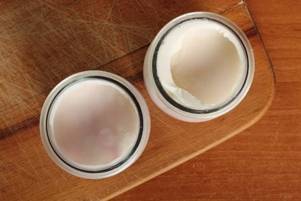 酸奶在木制切菜板上打开小玻璃瓶 直接在上面 — 图库照片