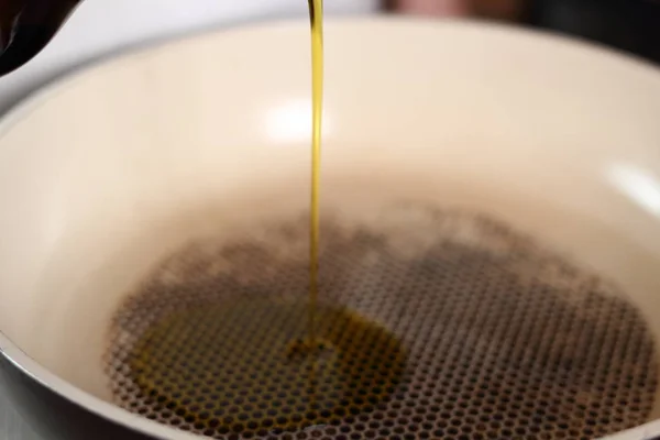 Pouring olive oil into frying pan. Making Lasagna Bolognese Series.