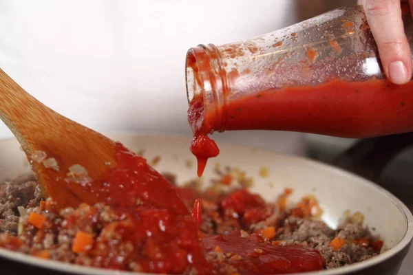 将番茄酱放入磨碎的肉中 制作烤宽面条系列 — 图库照片