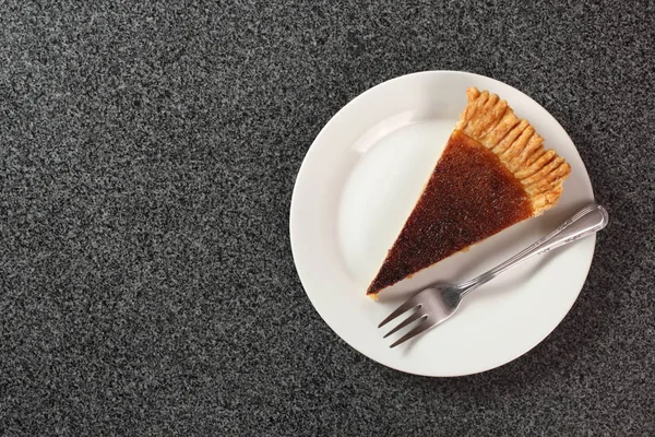 Piece of shortcrust pastry with cider filling on plate on granite surface. Cider Pie. Copy Space. Directly Above.