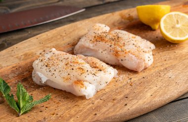 İki adet ahşap kesme tahtası üzerinde çiğ balık