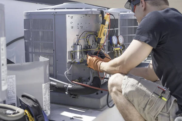HVAC technician working on controls of air conditioner — Stock Photo, Image