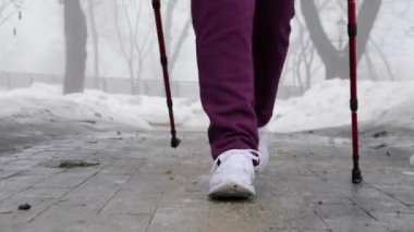Batonlu yürüyüş. Nordic Polonyalılar ile genç tombul beyaz kadın yürüyüş. Kameraya doğru yakın