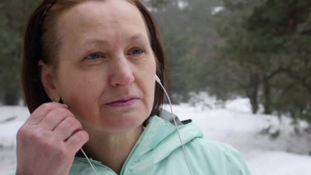 Starszy Stary Kaukaski Kobieta Stawia Słuchawkach Przed Uruchomieniem Snowy Winter — Wideo stockowe