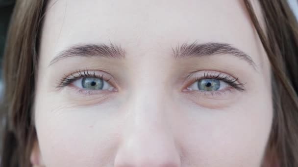 Close-Up shot a vonzó szép nő, kék szeme könnyű nap make-up és élességállítás. Keresi a kamerát — Stock videók