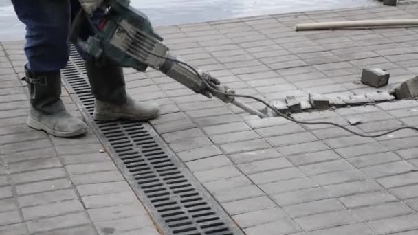 Trabajador de la construcción elimina baldosas de hormigón con la máquina de perforación de martillo neumático al aire libre — Vídeos de Stock