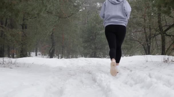 Trail Run. Young Attractive Caucasian girls running in the forest on the snow. Back static shot. Slow Motion — Stock Video