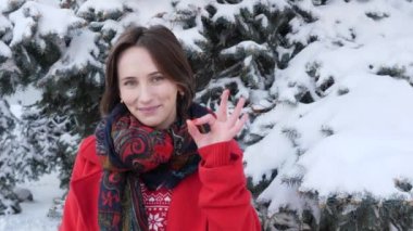 Çekici güzel kız jestleri yapma ve gülümseyen Genç yetişkin dışında ok işareti yapar.