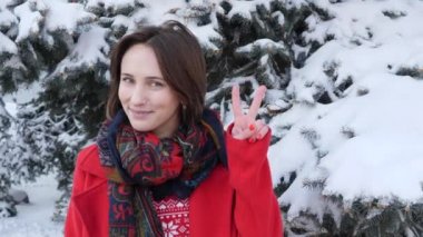 Çekici güzel kız Genç Yetişkin hareketleri yapma ve gülümseyen dışında barış işareti yapar.