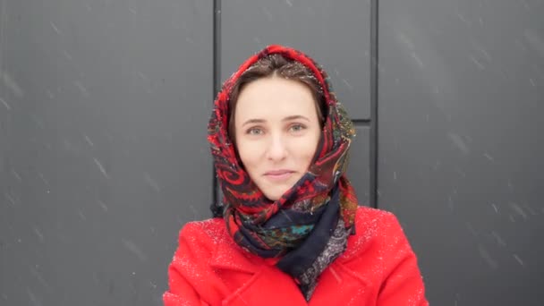 Красивая молодая кавказка, завернутая в тёплое красное пальто, улыбающаяся в камеру с зубными скобками — стоковое видео