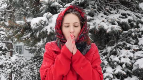 冬のアウトドアで息ジャンプで彼女の凍った手を温めようとしている美しい若い女性 — ストック動画