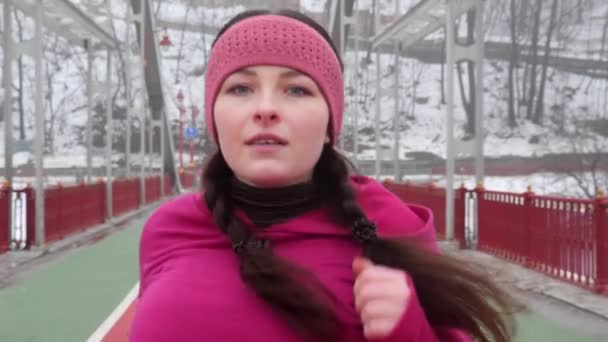 Gadis gemuk Kaukasia muda berjalan di atas jembatan. Tembakan di depan. Gerakan lambat. Pakaian ungu — Stok Video