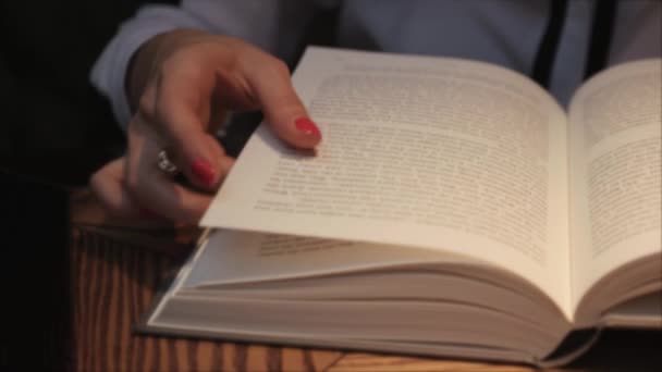 Jonge vrouw openen en lezen van een boek, terwijl het drinken van koffie in gezellig cafe. Business dame het lezen van een boek. Close-up te bekijken. Studeren voor lessen — Stockvideo