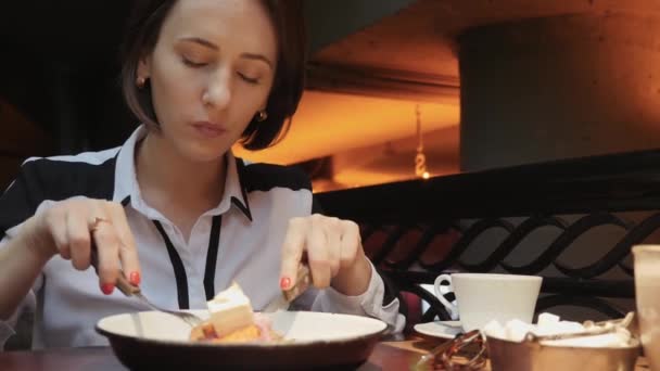 Jovem mulher de negócios atraente está almoçando em um restaurante acolhedor. Comer salada vegetariana e beber café. Vista de perto — Vídeo de Stock