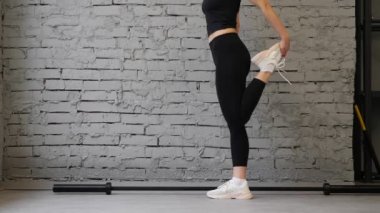 Yakın çekim kadın fitness Beyaz ayakkabı. Spor salonu veya ev, kardiyo egzersiz, güzel bacaklar çalışan detay egzersiz. Heykel, bacaklar egzersiz şekli. Spor ayakkabıları eğitim sportswoman.