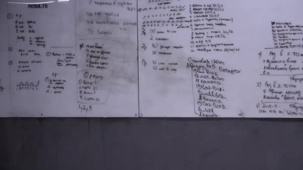 Белая доска с тренировочным планом в спортзале на стене — стоковое видео