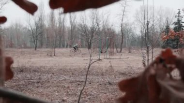 Kiev/Ukrayna-Şubat, 24 2019 Kiev cyclocross Kupası. Ağaçlardan geçen bisikletçi