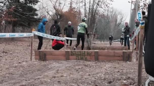 Kiev/Oekraïne-februari, 24 2019 Kiev Cyclocross Cup. Groep fietsers sprong over de barrière — Stockvideo